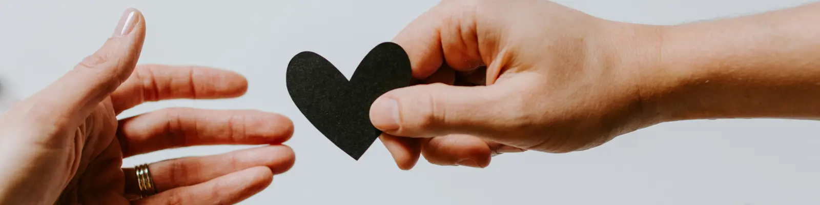 hand handing heart to other hand