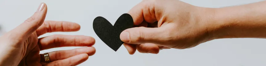 hand handing heart to other hand